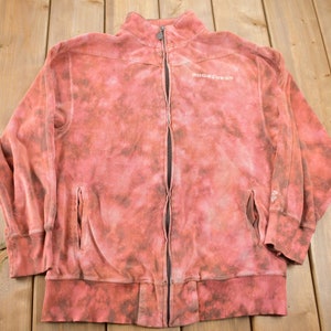 May include: A red tie-dye zip-up sweatshirt with the word "ROCHESTER" printed on the front.