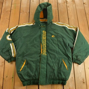 May include: Green and yellow hooded puffer jacket with the word "PACKERS" embroidered on the front. The jacket has white stripes on the sleeves and a small logo on the chest.