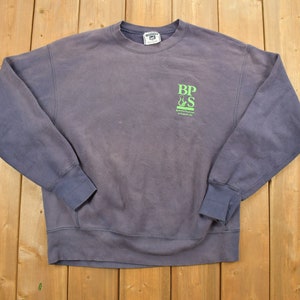 May include: A purple sweatshirt with a green logo that says "BPS" and "Brew Pub & Sports Bar" with a small logo of a beer mug and a baseball bat.