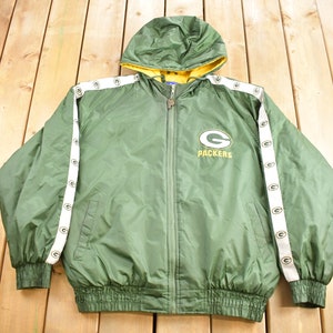 May include: Green and yellow hooded jacket with white stripes and the Green Bay Packers logo. The jacket has a zipper closure and a drawstring hood.