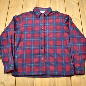 May include: A red and blue plaid long-sleeved button-up shirt.
