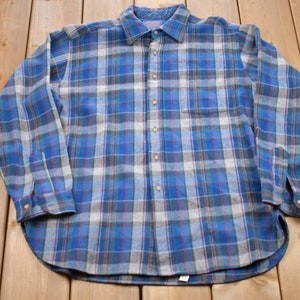 May include: A blue and gray plaid flannel shirt with long sleeves and a button-up front.