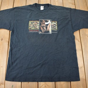 May include: Black t-shirt with a graphic of a bison and the text "Battle Rock Shop, Custer State Park".
