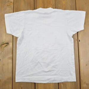 May include: A plain white t-shirt with a crew neck.