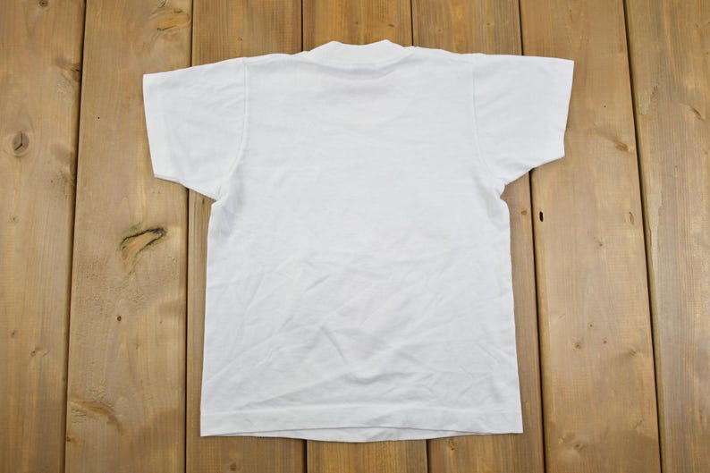 May include: A plain white t-shirt with a crew neck.