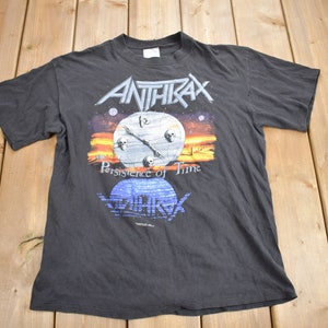Puede incluir: Camiseta negra con un gráfico de una esfera de reloj con calaveras y el texto "Anthrax Persistence of Time".
