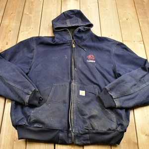 Może przedstawiać: Granatowa kurtka robocza z kapturem, zapinana na zamek błyskawiczny, z logo "Lumberjack" na lewej piersi. Kurtka ma dwie kieszenie z przodu i kaptur ze sznurkiem.