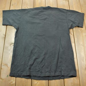 May include: A plain dark gray t-shirt with short sleeves.