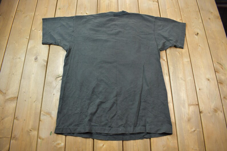 May include: A plain dark gray t-shirt with short sleeves.