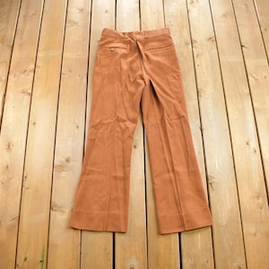 May include: A pair of brown wide-leg trousers with a straight fit from the waist to the knee, then flaring out to the hem.