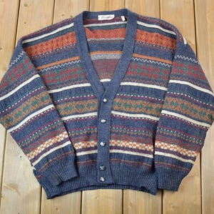 May include: A blue, brown, and white striped cardigan with a V-neck and button closure.