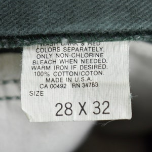 Może przedstawiać: Biała metka z czarnym tekstem, kt&oacute;ry brzmi: "WASH DARK & RED COLORS SEPARATELY. ONLY NON-CHLORINE BLEACH WHEN NEEDED. WARM IRON IF DESIRED. 100% COTTON/COTON. MADE IN U.S.A. CA 00492 RN 34783 SIZE 28 X 32"