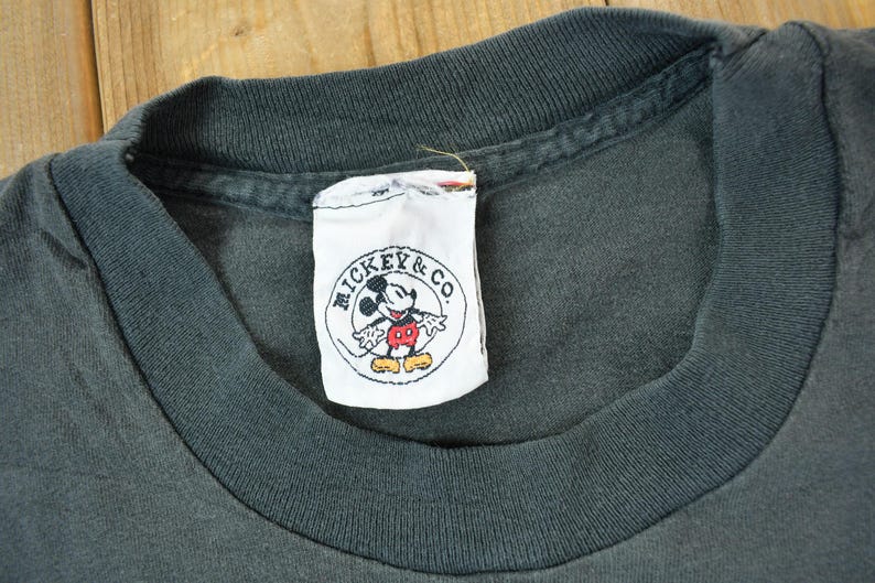 May include: A black t-shirt with a white tag that says "Mickey & Co." and features a cartoon image of Mickey Mouse.