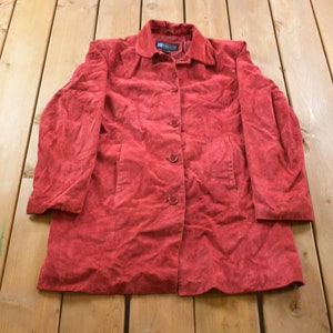 May include: A red suede jacket with a button closure and two pockets.