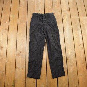 May include: A pair of black trousers with a button fly and belt loops.