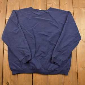 Puede incluir: Una sudadera de manga larga azul marino con cuello redondo.