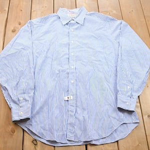Peut inclure: Une chemise à manches longues à rayures bleues et blanches avec un col et des poignets blancs.