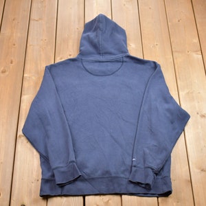 May include: A dark blue hooded sweatshirt with long sleeves and a pouch pocket. The sweatshirt is made of a soft, comfortable fabric.