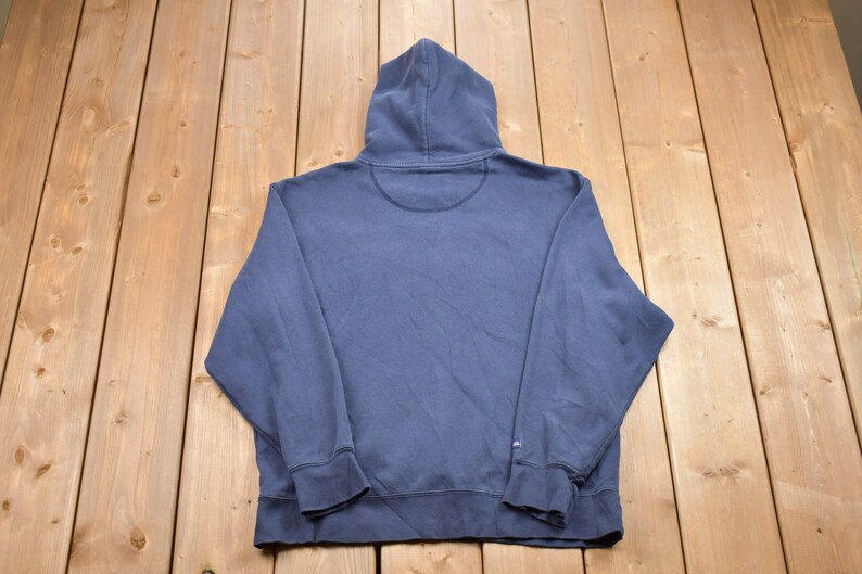May include: A dark blue hooded sweatshirt with long sleeves and a pouch pocket. The sweatshirt is made of a soft, comfortable fabric.
