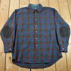May include: A long-sleeved plaid shirt with elbow patches. The shirt is green, blue, red, and white.