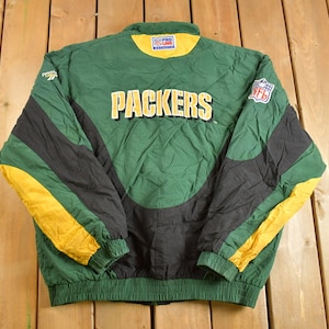 May include: Green, black, and yellow reversible jacket with the word "Packers" in white lettering on the front. The jacket has a zipper closure and a stand-up collar.