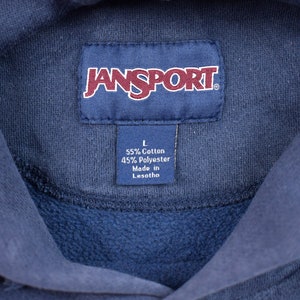 May include: A navy blue Jansport hoodie with a tag that reads "L 55% Cotton 45% Polyester Made in Lesotho."