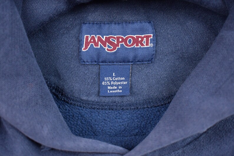 May include: A navy blue Jansport hoodie with a tag that reads "L 55% Cotton 45% Polyester Made in Lesotho."