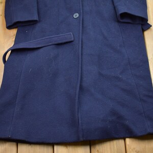Pu&ograve; includere: Un cappotto di lana blu navy con una chiusura a bottone singolo e una cintura. Il cappotto ha un design classico ed &egrave; in buone condizioni.