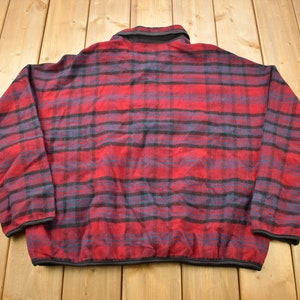 May include: A red and blue plaid fleece jacket with a zip closure.