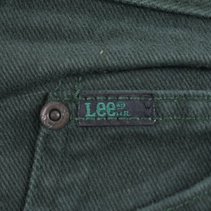 May include: Close-up of a dark green pair of pants with a black Lee&reg; label sewn on the back pocket.