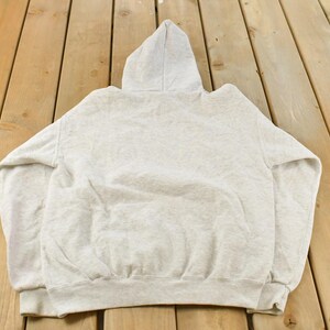 Op de afbeelding: Een lichtgrijze gem&ecirc;leerde hoodie met lange mouwen, een capuchon met trekkoord en een kangoeroezak aan de voorzijde. Het kledingstuk is gemaakt van zachte fleecestof met geribbelde boorden aan de polsen en een geribbelde zoom aan de onderkant.