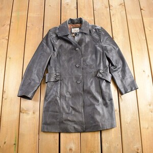 May include: A black leather trench coat with a button closure and a belt. The coat has a classic design and is made of high-quality leather.