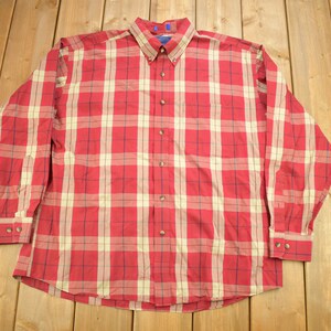May include: A long-sleeved button-down shirt with a red and white plaid pattern.