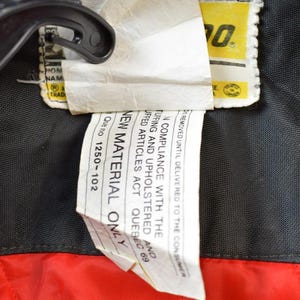 May include: A white tag with black text that reads "NEW MATERIAL ONLY" and "Que no 1250-102". The tag is attached to a black fabric with a yellow tag that reads "WOW" in black text.