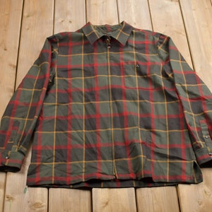 May include: A long-sleeved plaid shirt with a zip closure. The shirt is green, red, black and yellow.