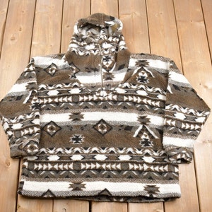 May include: A brown and white patterned fleece pullover with a zippered neckline and a hood.