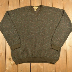 May include: A dark green, brown, and red speckled v-neck sweater.