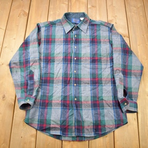 May include: A long-sleeved plaid shirt with a blue, green, red and white pattern. The shirt has a button-down collar and a button-up front.