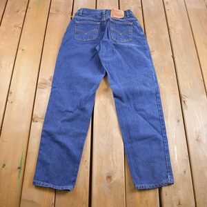 May include: A pair of blue denim jeans with a brown leather patch on the back.