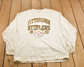 Könnte beinhalten: Weißes Langarm-T-Shirt mit einem schwarzen und gelben Pittsburgh Steelers Logo und dem Text "Pittsburgh Steelers 19 33".