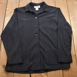 以下が含まれることがあります： 4つのボタンと2つのポケットが付いた、黒のストライプのロングスリーブシャツ