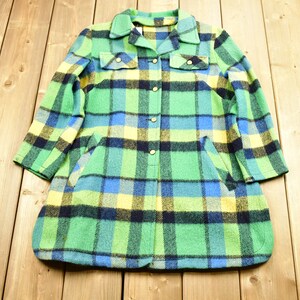 K&ouml;nnte beinhalten: Eine lang&auml;rmelige karierte Jacke mit Knopfleiste. Die Jacke ist gr&uuml;n, blau, gelb und schwarz.