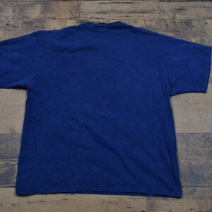 May include: A plain navy blue t-shirt. The shirt is a basic style with short sleeves and a crew neck.