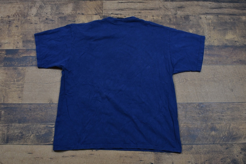 May include: A plain navy blue t-shirt. The shirt is a basic style with short sleeves and a crew neck.