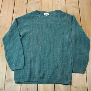 May include: A teal blue knitted sweater with a cable knit pattern.