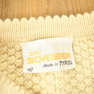 May include: A white knitted sweater with a label that reads "SIGI SCHEIBER Made in TYROL" and the number "40".