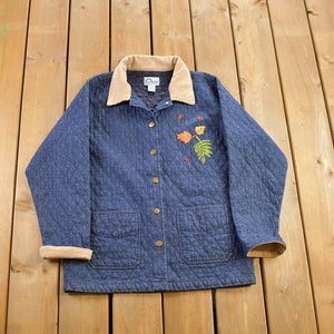May include: A blue denim quilted jacket with a brown corduroy collar and embroidered autumn leaves. The jacket has two front pockets and a button closure.
