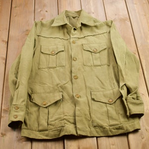 May include: A khaki green utility jacket with multiple pockets and button closures.