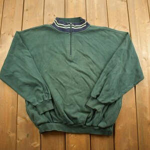 Peut inclure: Un sweat-shirt à manches longues vert foncé avec une fermeture éclair quart et un col rayé bleu marine et blanc.