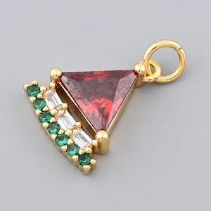 May include: Gold-toned pendant with a triangular red gemstone and a curved row of green and white stones. The pendant has a small loop for attaching to a chain or bracelet. The design is geometric and elegant.